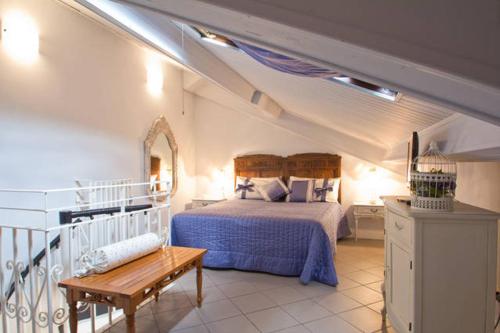 因佩里亚Case Vacanze Borgo Marina IMPERIA的一间卧室配有一张床,卧室配有长凳