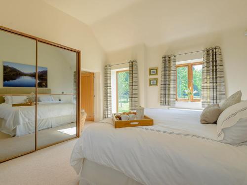 埃德温斯托Courtyard Lodge的卧室配有一张白色大床和镜子