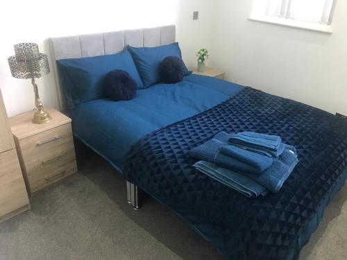 唐克斯特Executive Apartment Central Doncaster的床上铺有蓝色床单和蓝色毛巾