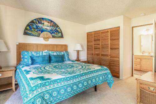 唯客乐渡假村Hale Honu的一间卧室配有一张大床和蓝色的床罩