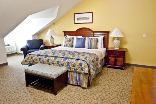 纽波特Oceancliff I & II, a VRI resort的配有一张床和一把椅子的酒店客房