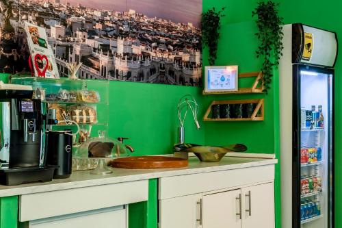 马德里OXYGEN HOSTEL Capsula的厨房设有绿色的墙壁和带水槽的台面