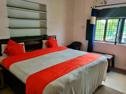JhirnaJim Corbett Home stay的一间卧室配有一张带红色枕头的大床