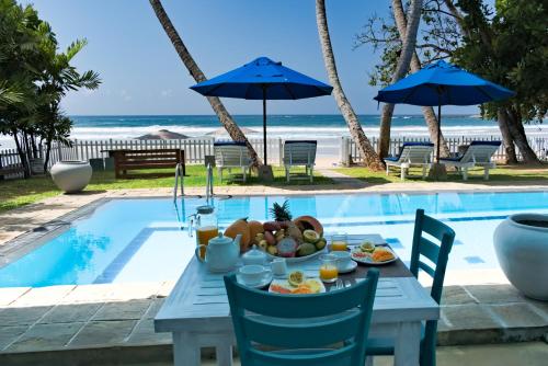 迪克韦勒Smeralda Beach Hotel Dikwella的一张桌子,旁边是一张盘子的食物
