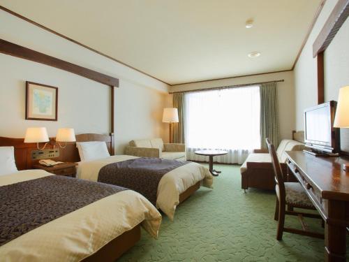 大崎市Hotel Onikoube的酒店客房配有两张床和一张书桌