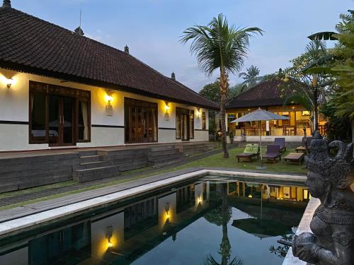 海神庙Agung Village的夜间带游泳池的别墅