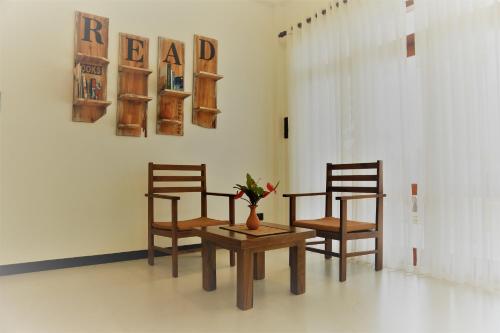 本托塔Villa Maria的一张桌子和两把椅子,一张桌子和花瓶