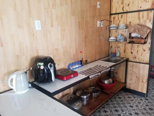 大叻MOre Home - Ngôi nhà nghĩ dưỡng tại Đà Lạt的厨房配有带水槽和炉灶的台面