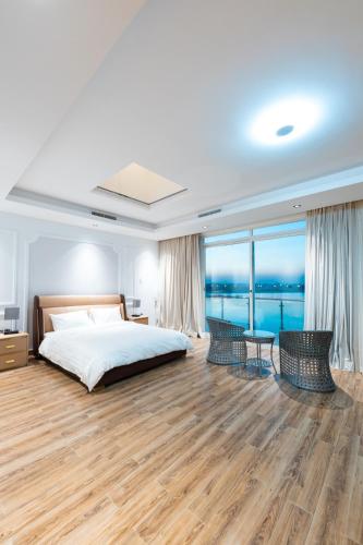 An NāmīGrande Beach的一间卧室配有一张床,享有海景
