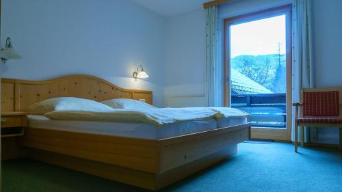 格吕瑙Pension Wanderruh的一间卧室设有一张大床和一个大窗户