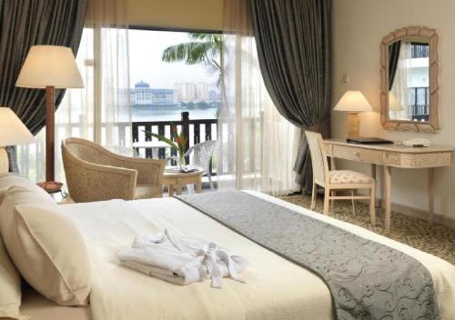 史里肯邦安Mines Beach Resort Hotel的配有一张床、一张书桌和一扇窗户的酒店客房