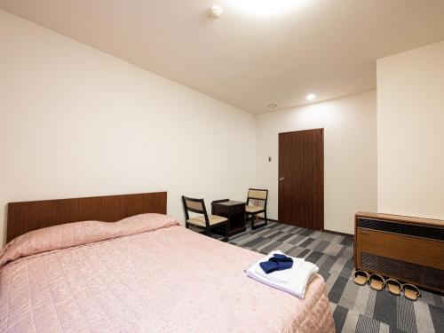 SagamichōTabist Ooriya Kochi的卧室配有一张床和一张桌子及椅子
