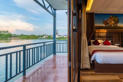 拉明德Lumbini Palace Resort的阳台配有一张床,享有水景