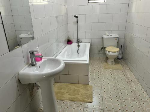 KasiyirizeSpacious and comfortable House in Kampala Uganda的白色的浴室设有水槽和卫生间。