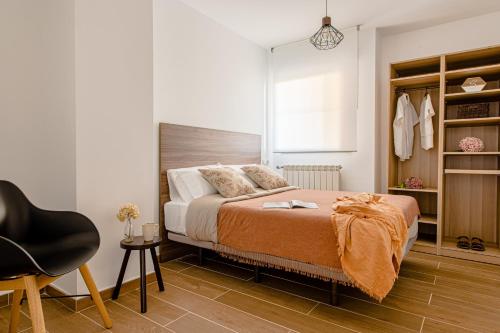 桑坦德Estilo japandi Sardinero的一间卧室配有一张床和一把椅子