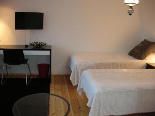LohjaVohloisten Kartano的客房设有两张床、一张桌子和电视。