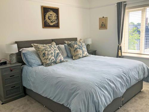 赫斯沃尔May Escape的一间卧室配有一张大床,提供蓝色的床单和枕头