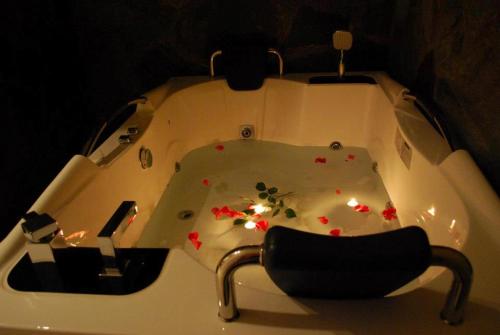 阿尔奈阿科纳基酒店的浴缸里装有鲜花,配有椅子