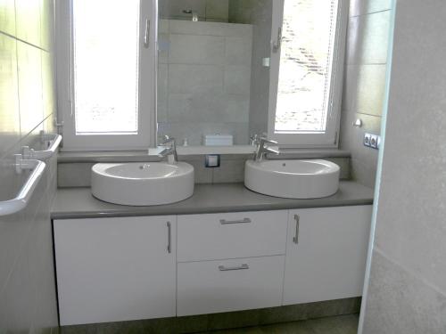 蒂哈拉费Villa Atlantico - beheizter Pool, Sauna的白色浴室设有两个盥洗盆和两个窗户。