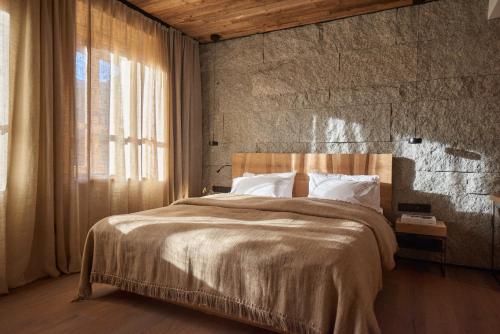 扎科帕内EnHotel的一间卧室设有一张大床和石墙