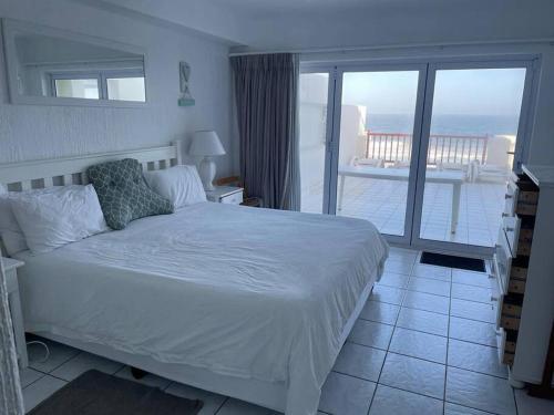 巴利托9 Skiathos - Beach front apartment - Salt Rock的一间带白色床的卧室和一个阳台