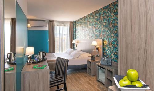 圣拉斐尔Unique Hôtel & Spa的配有一张床和一张书桌的酒店客房