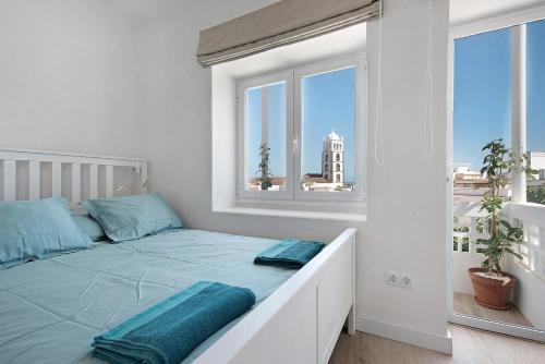 加拉奇科Casa Sol 21 A Garachico的白色卧室配有一张带蓝色枕头的大床