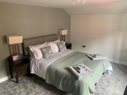 绍斯韦尔RECENTLY RENOVATED property in the heart of Southwell的一间卧室配有一张带绿毯和枕头的床。
