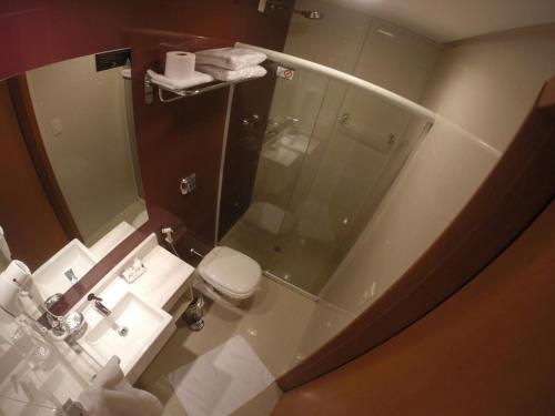 桑托斯阿兰蒂科金色公寓酒店的一间带玻璃淋浴和卫生间的浴室