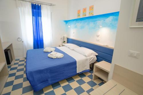 努马纳EDEN CONERO Camere Numana Centro的一间卧室配有蓝色的床和毛巾