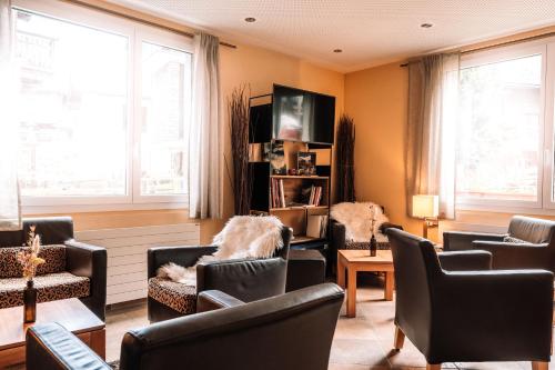 萨斯费Hotel Les Amis的客厅配有椅子、电视和窗户。