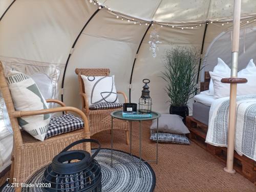 巴姆施泰特Glamping Altes Pastorat的带帐篷、床和桌子的客房