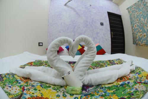 斋沙默尔Chandra Haveli Boutique Homestay的床上的两条毛巾天鹅