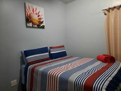 LangstrandThe Dolphin View 4的一间卧室配有一张带彩色条纹毯子的床