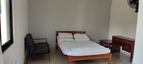 BacunganEco greene farm的小房间设有一张床、一张桌子和一把椅子