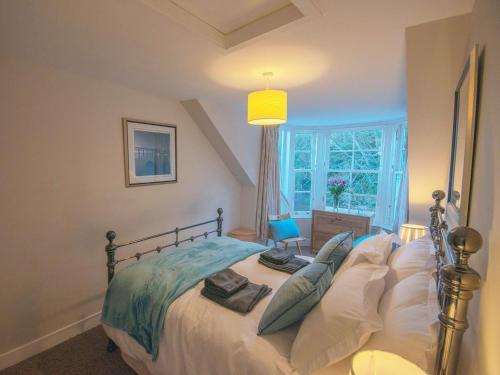 昆斯费里Forth Reflections的卧室配有带枕头的床铺和窗户。