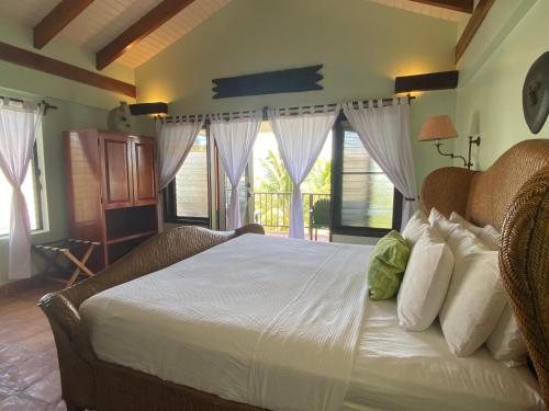 珀拉什奇亚Tranquility Beach Suites的一间卧室配有一张带白色床单和窗户的床。