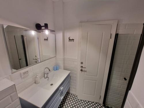 内坦亚Beautiful 2-Bedroom Sea-View apartment的白色的浴室设有水槽和镜子