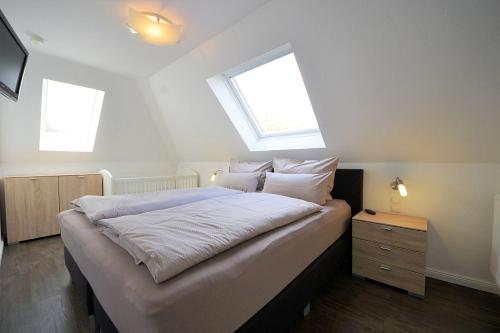 万根沃格Ferienwohnung Kellingooge的一间卧室设有一张大床和两个窗户
