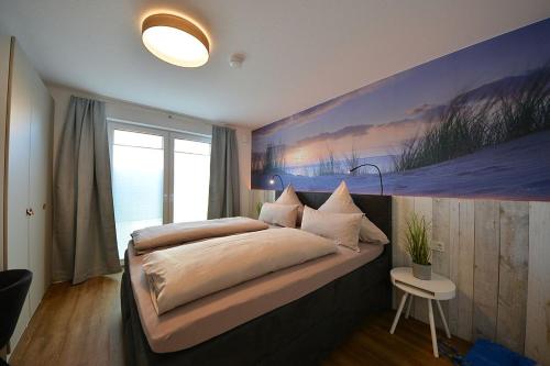 万根沃格Ferienwohnung STRAND PIET的一间卧室配有一张壁画大床