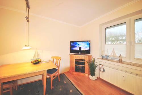 万根沃格Ferienwohnung am Damenpfad的客厅设有餐桌和电视