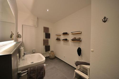 万根沃格Ferienwohnung STRAND PIET的白色的浴室设有水槽和镜子