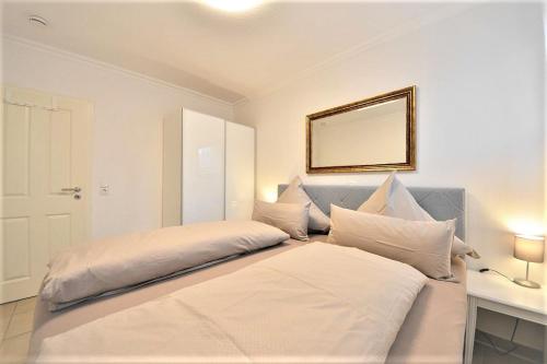 万根沃格Villa Vivaldi - Ferienwohnung 3的一间卧室设有两张床,墙上设有一面镜子