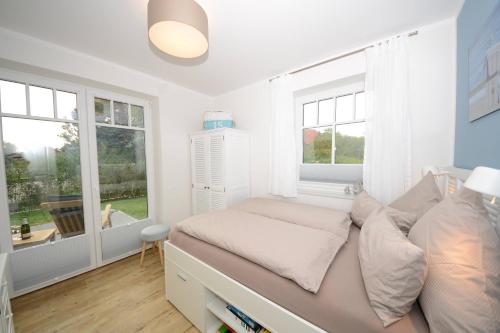 万根沃格Ferienwohnung Strandbude的一间卧室设有一张床和两个窗户。