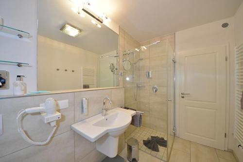 万根沃格Villa Verdi - Ferienwohnung 2的白色的浴室设有水槽和淋浴。