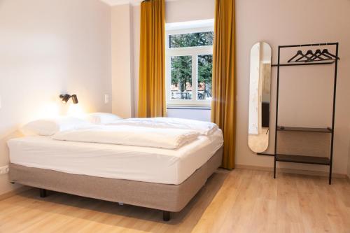 瓦森贝格Gitstapper Hof的一间卧室配有一张带窗户和镜子的床