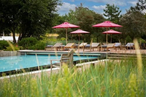 圣彼得奥尔丁阿勒尔福斯Spa酒店的一个带椅子和遮阳伞的游泳池
