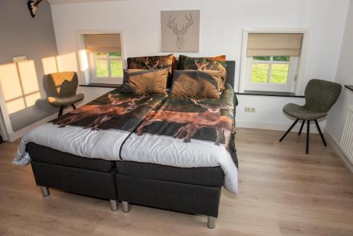 LiempdeDe Donksehoeve的一间卧室配有一张大床和两把椅子