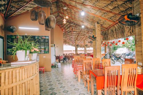 宁平Tam Coc Sky Bungalow的一间带木桌椅的餐厅和一间酒吧