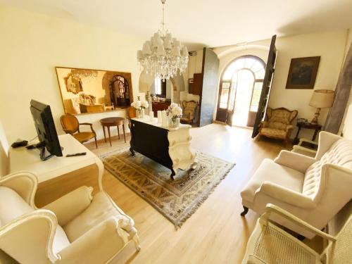 阿莱利亚Masia del siglo XIV cerca de Barcelona的客厅配有白色家具和吊灯。